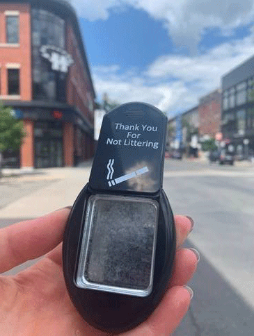 Woman's hand holding a pocket ashtray "Thank you for not littering"