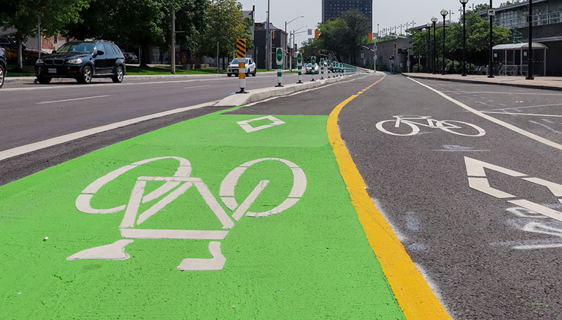 Photo of bike box, painted green with bicycle stencil at stop light