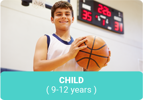 Smiling tween boy holding a basketball in a gymnasium
