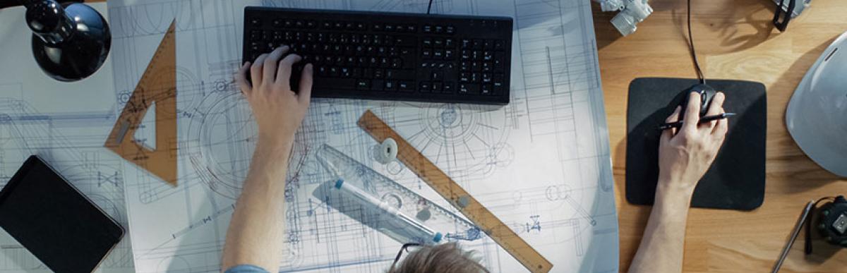 Engineer at desk working on his blueprints