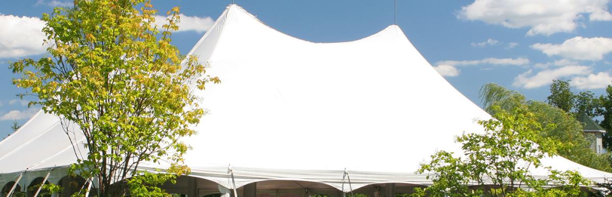 Large white tent erected in backyard of house for event