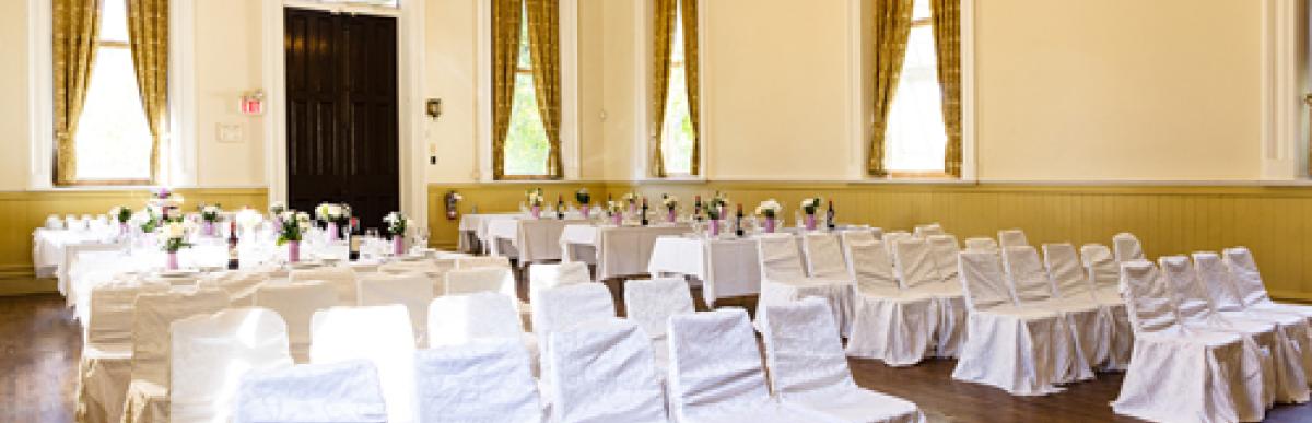 Chairs lined up in rows draped in white linens