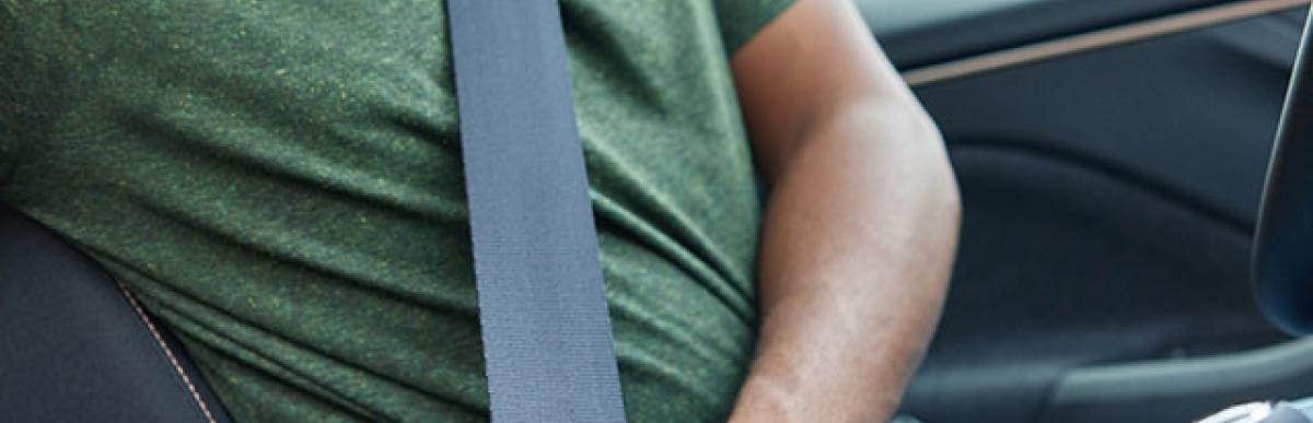 Man buckling seatbelt in car