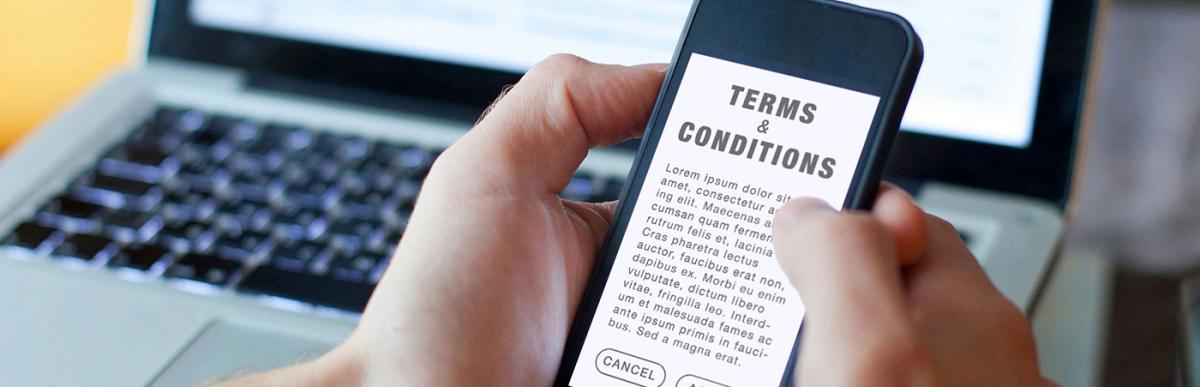 Terms and conditions, man reading agreement on the screen of smartphone
